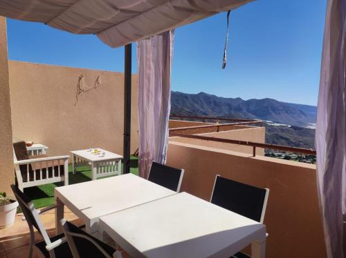 a table and chairs on a balcony with a view at Ático con vistas al mar in Vícar