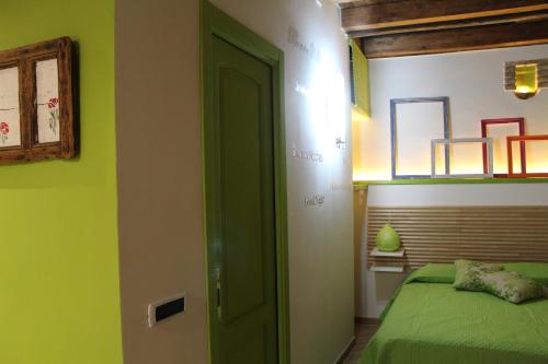 a green room with a bed and a green door at Guest House La Casetta in Piazza Armerina