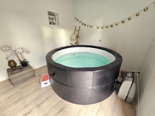 a bath tub in a room with a bath tub at Le pont T3 étoilé avec jacuzzi in Saint-Méloir-des-Ondes