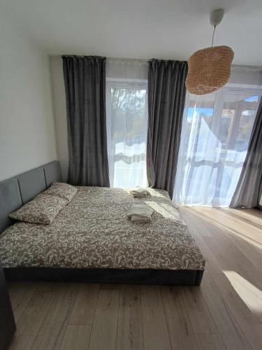 um quarto com uma cama e uma grande janela em Wielicka Apartment 3 em Cracóvia