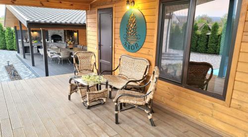 a patio with wicker chairs and a table on a deck at Хвоя - комплекс відпочинку in Boryspilʼ