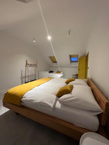 a bedroom with a large bed with white sheets and yellow blankets at Chalet Furmanski in Stará Lesná