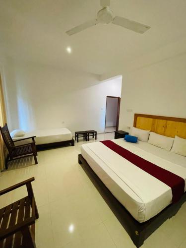 a bedroom with a large bed with a ceiling at Villa Red Lobster in Hikkaduwa