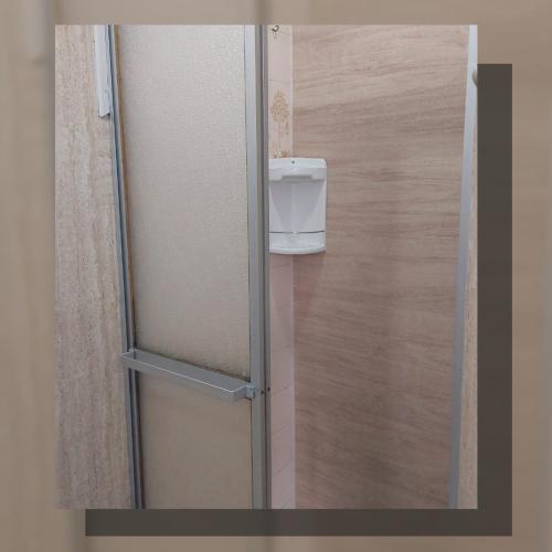 a glass refrigerator with a dispenser in a room at Apartamento com piscina, apenas 200 metros do mar in Capão da Canoa