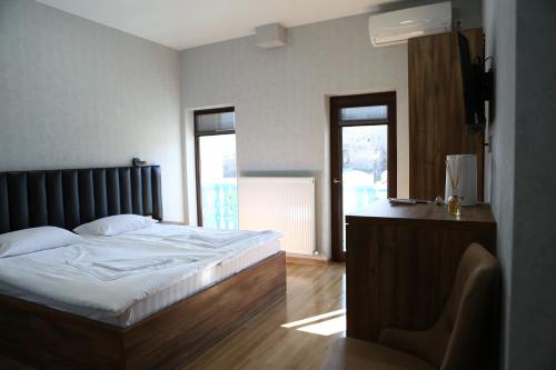 a bedroom with a bed and a desk with a chair at Luxor Rabath in Akhaltsikhe