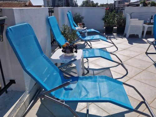 three blue chairs and a table on a patio at Apartments Tamara in Budva
