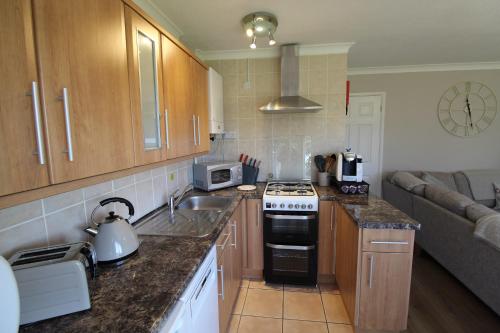 a kitchen with a sink and a stove top oven at Driftwood Heart in Freshwater
