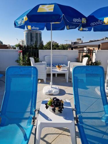 two chairs and an umbrella on a patio at Apartments Tamara in Budva