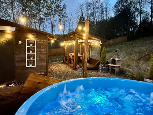 una gran bañera llena de agua azul en un patio en Bieszczadzka Osada Saunowisko-dom z jacuzzi sauną na wyłączność, en Solina