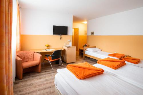 a hotel room with two beds and a desk at Penzion Kovac in Radovljica