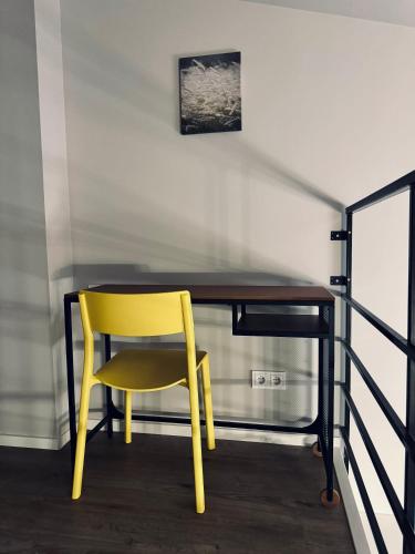 a yellow chair sitting at a desk in a room at AJ Chocolate Vilnius in Vilnius