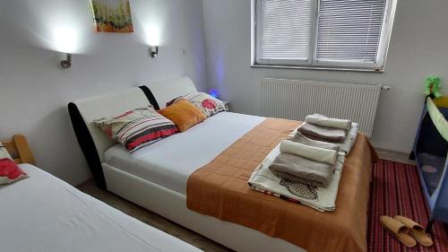 1 dormitorio con 1 cama con toallas en Apartments Window, en Bihać