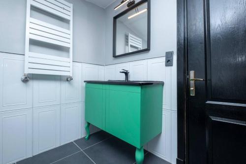ein grünes Waschbecken im Bad mit weißen Schränken in der Unterkunft Stylishly Decorated Fourlex House in Istanbul