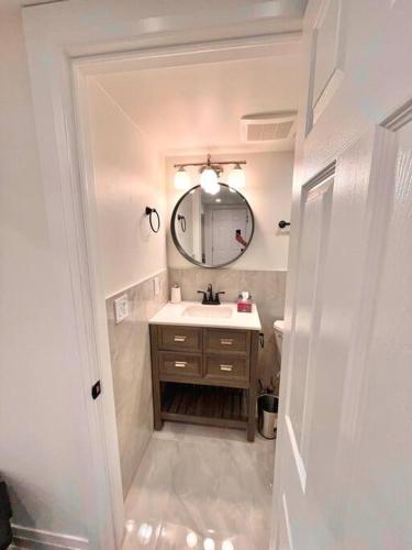 a bathroom with a sink and a mirror at Cozy basement studio unit in Oakville