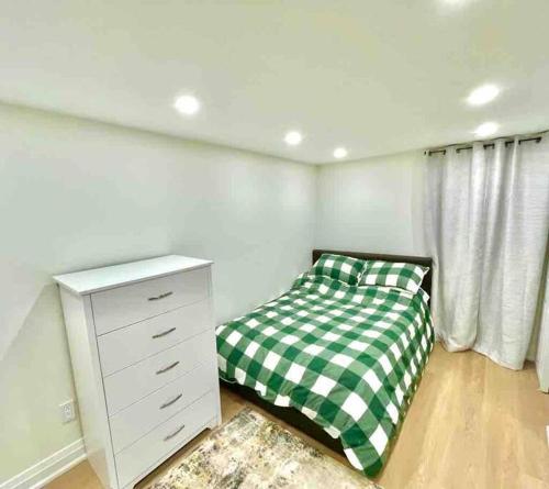 a bedroom with a green and white checkered bed at Cozy basement studio unit in Oakville