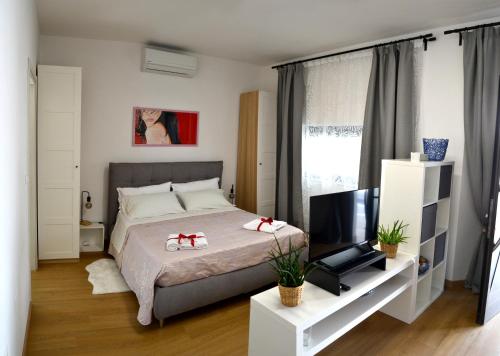 a bedroom with a bed and a flat screen tv at La Rocca sui Trabocchi in Rocca San Giovanni