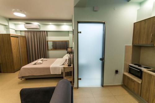 a room with a bed and a door to a kitchen at Nicolas Luxury Suites in Kourouta