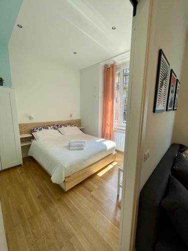 a bedroom with a large white bed and a wooden floor at Fiera-MiCo - Sempione Apartment in Milan
