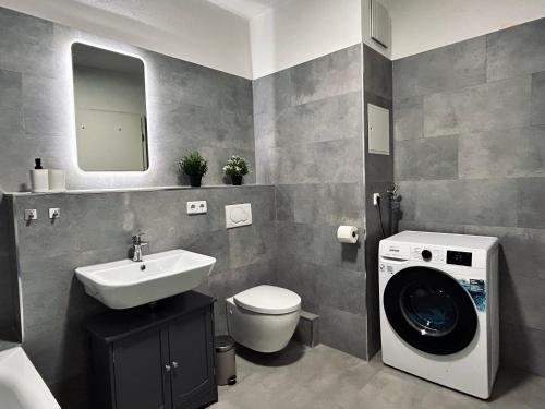 łazienka z umywalką i pralką w obiekcie 2 Schlafzimmer-Balkon-Küche-Parkplatz-Designerbad w Lipsku