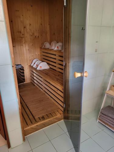 La salle de bains est pourvue d'une cabine de douche et d'étagères en bois. dans l'établissement Willa Sulimówka - Noclegi Zakliczyn dom basen bania sauna SPA, à Zakliczyn