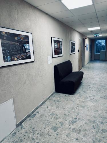 a waiting room with a black chair on a wall at AJ Chocolate Vilnius in Vilnius