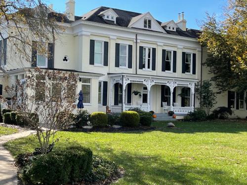 a large white house with a lawn in front of it at Riverside Inn Bed and Breakfast in Warsaw