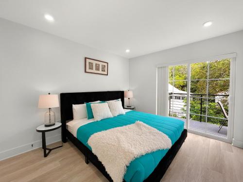a white bedroom with a blue bed and a window at Mary's Stay Brookland in Washington