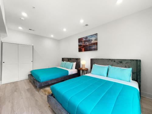 a bedroom with two beds with blue pillows at Mary's Stay Brookland in Washington