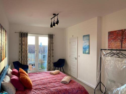 a bedroom with a large bed and a window at Homely, Cosy & Contemporary 4 BDR house with Garden & Parking 5 mins drive to Addenbrookes & Papworth hospitals & Bio Medical campus in Cambridge