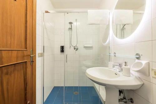 La salle de bains blanche est pourvue d'un lavabo et d'une douche. dans l'établissement Residenza degli Albizi, à Florence