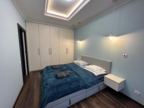 a bedroom with a large bed and white cabinets at Apartament Szarlotka in Łódź
