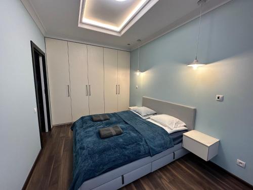 een slaapkamer met een groot bed en witte kasten bij Apartament Szarlotka in Łódź
