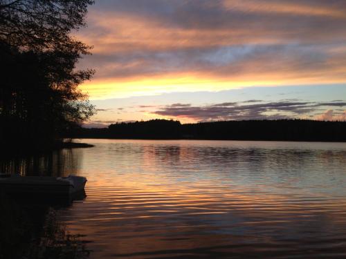 a sunset over a large body of water at Domek Leśny Reset in Studzienice