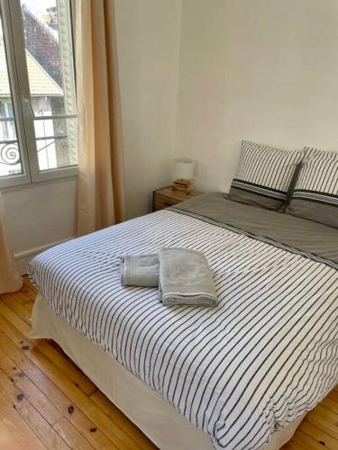 a bed with two towels on it in a bedroom at T3 de charme au centre de Clermont in Clermont-Ferrand