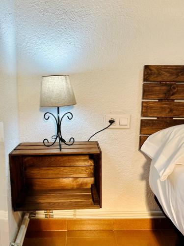 a lamp on a night stand next to a bed at Masía Can Janet in Arbúcies