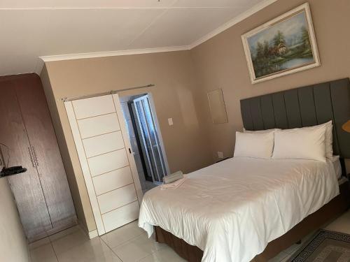 a small bedroom with a bed and a window at Azalea BnB in Kuruman