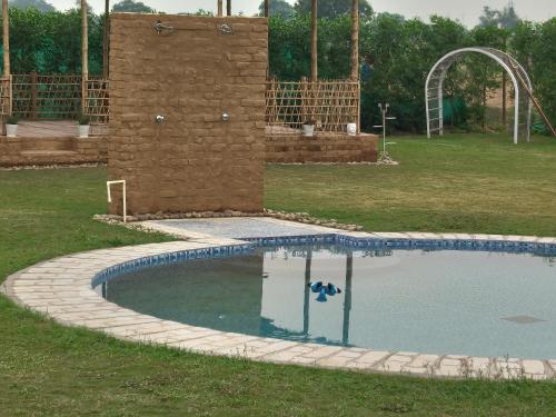 a swimming pool in a park with a water slide at TENTFORTABLE Village Retreat in Agra