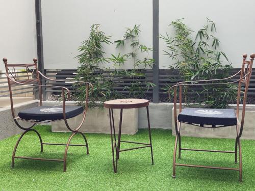 two chairs and a table and two chairs on grass at Departamentos Fleming, luminosos p hasta 4 personas in Paraná
