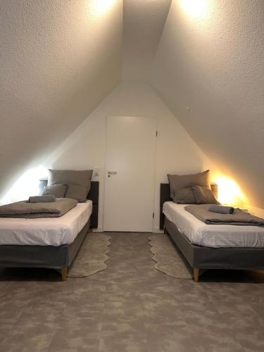 a bedroom with two beds and a white door at Apartment by Harbali in Schüttorf