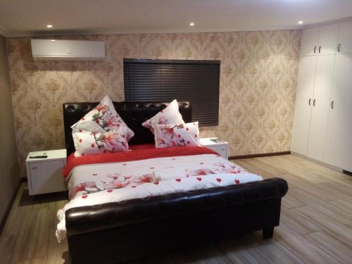 a bedroom with a bed with a black leather headboard at Villa43guesthouse in Cape Town