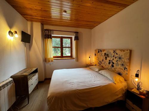 sypialnia z dużym łóżkiem i oknem w obiekcie El Niuet w mieście Pla de l'Ermita