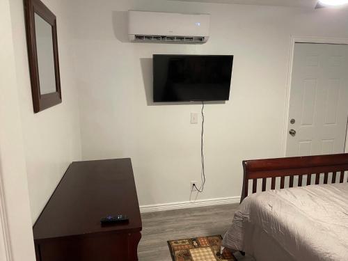a bedroom with a bed and a flat screen tv on the wall at Crazy Horse - APT 1 in Kanab