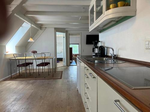 cocina con encimera y mesa con sillas en Skovridergaardens Ferielejligheder, en Aabenraa