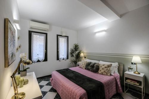 a bedroom with a bed with a pink blanket at Secret Garden - Villafranca di Verona centro in Villafranca di Verona