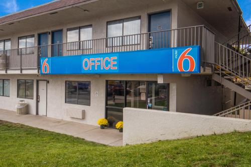 a office building with a blue sign in front of it at Motel 6-Elko, NV in Elko