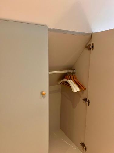 a bathroom with a closet with a door and towels at Huyze Ter Vaete in Lo-Reninge
