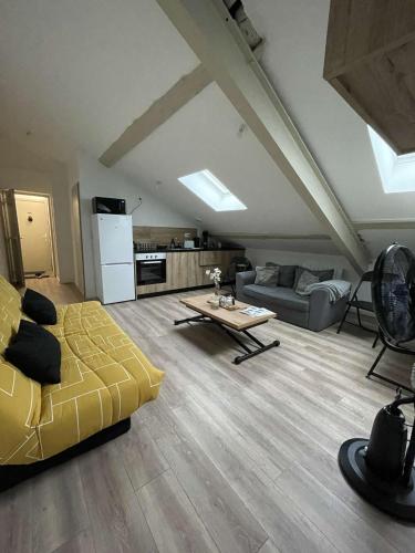 ein Wohnzimmer mit einem gelben Sofa und einem Tisch in der Unterkunft T2 Cosy - Terrasse - Proche du stade - 401 in Saint-Étienne