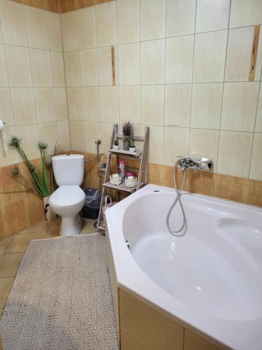 a bathroom with a white tub and a toilet at Willa Sulimówka - Noclegi Zakliczyn dom basen bania sauna SPA in Zakliczyn