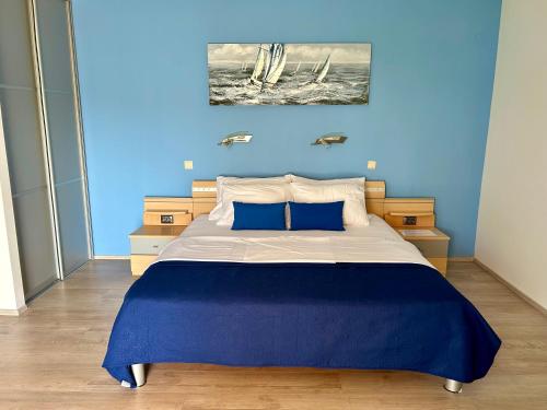 een slaapkamer met een groot bed met blauwe muren bij Apartment Stella in Mali Lošinj