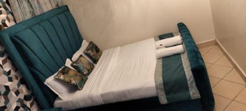 ein Schlafzimmer mit einem grünen Bett mit Kissen in der Unterkunft Soneyhomes in Nairobi